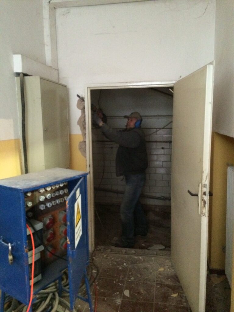 In der alten Schule gab es viel zu tun - hier wird eine alte Tür mit schwerem Gerät entfernt.